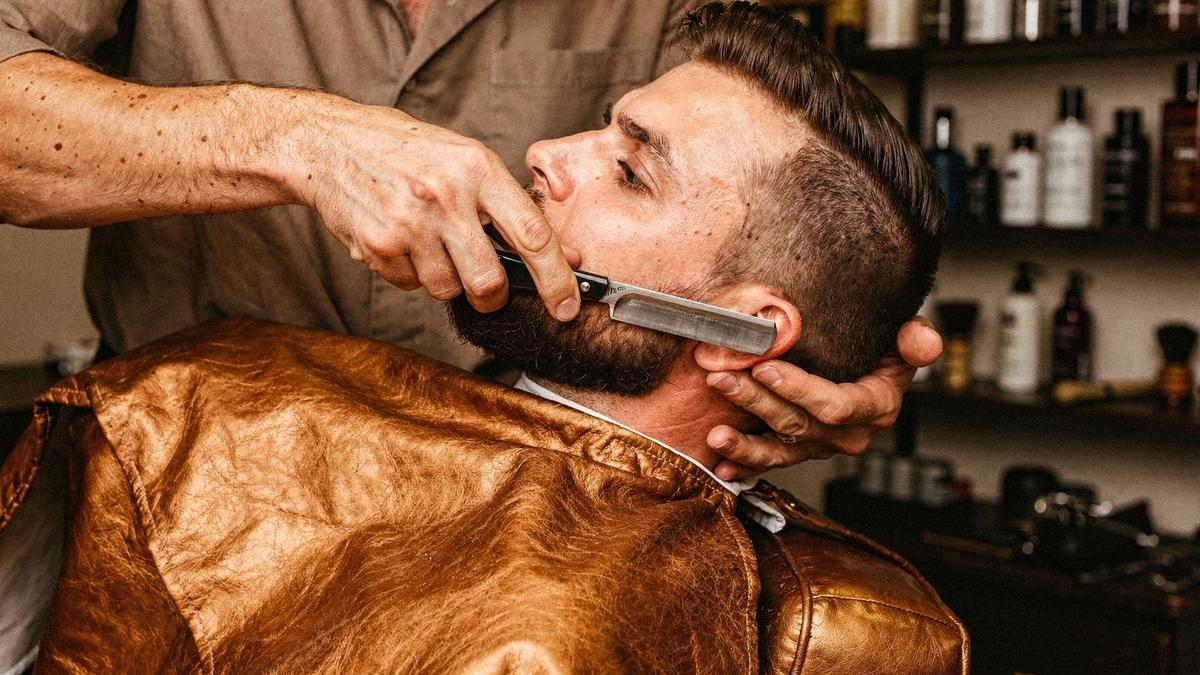 Barber defining a beard line with a straight razor in a Kyiv studio